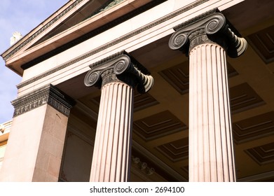 A detail of an old building built in the old Greek style with Ionic columns.