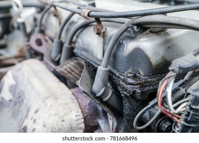 A Detail Of The Old Car Wreck. The Engine With Spark Plugs. The Oil Leak Is On It. 