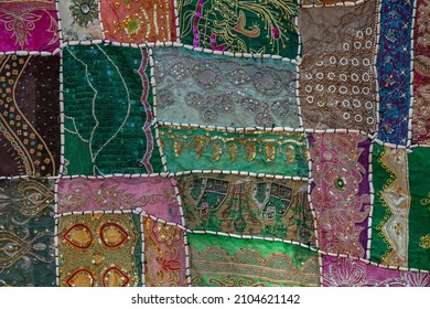 Detail old colorful patchwork carpet in background, India. Close up