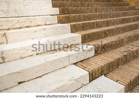 Detail of an old italian chiseled stone staircase whit stone blocks and terracotta bricks