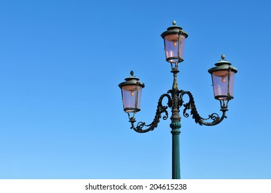 Detail of old street lamp against blue sky