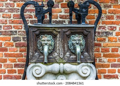 Detail of an old water pump decorated with lions carved faces and decorations at the Groot Begijnhof (Great Beguinage), a restored historical quarter in the south of downtown Leuven, Belgium