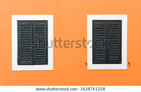 Detail of olf wooden window with closed shutters.