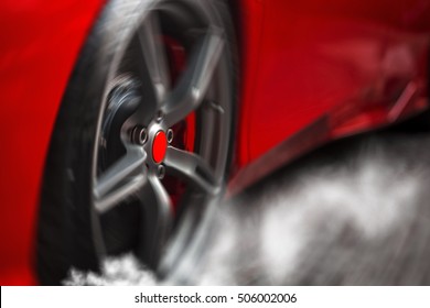 Detail On Hot Red Super-sport Car Spinning Wheel With Sport Breaks Covered In Tire Smoke