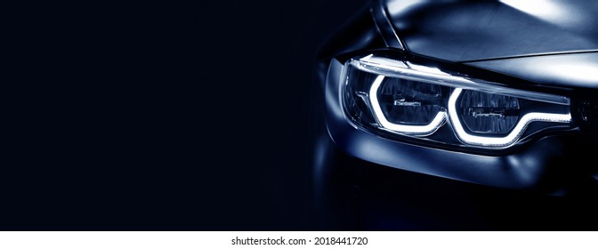 Detail on one of the LED headlights modern car on black background,	free space on left side for text.