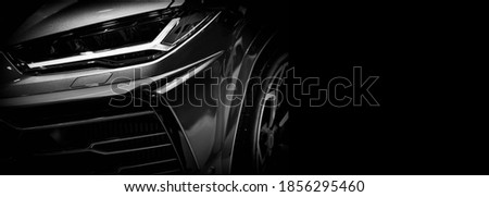 Detail on one of the LED headlights super car on black background, free space on right side for text.