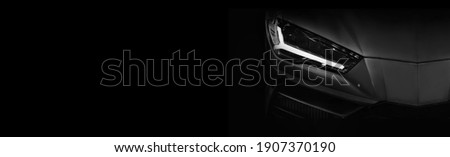 Detail on one of the LED headlights super car on black background, free space on left side for text