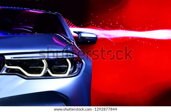 Detail on one of the LED headlights modern car\
on red background