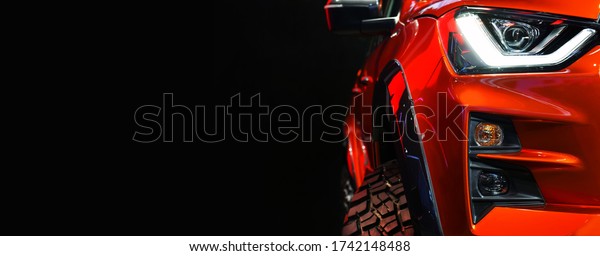 Detail on one of the LED headlights\
red Pickup Truck on black background,copy\
space