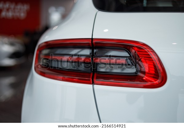 Detail\
on the rear light of a car. Car detail. Developed Car\'s rear brake\
light. The car is in the showroom. Automotive concept. Classic\
white color. The car is in the showroom. LED\
light