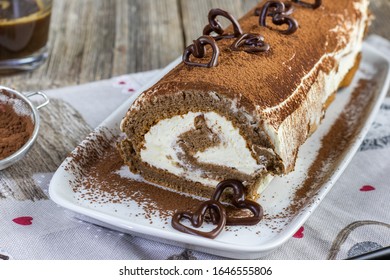 Detail On A Tiramisu Roulade On White Cocoa Tray With Dark Chocolate Hearts