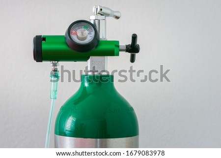 Detail of an oxygen pressure gauge and cylinder with white background