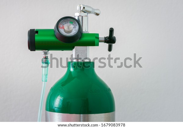 Detail of an oxygen pressure gauge and\
cylinder with white\
background