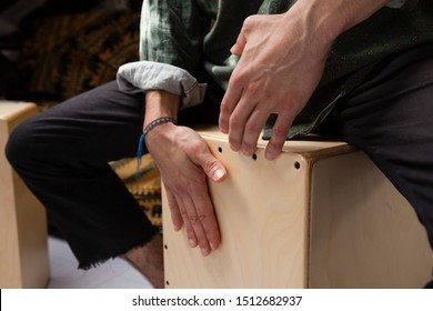 Detail of a percussionist male hands while playing flamenco drumbox at home studio with natural light. Flamenco instruments and musicology concept. 