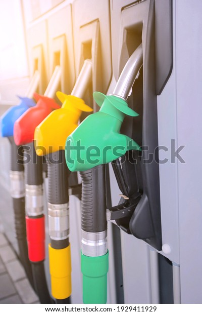 Detail of a petrol pump in a\
petrol station.Close up on fuel nozzle in oil dispenser with\
gasoline and diesel in service gas station. Blue, green, red,\
golden colors