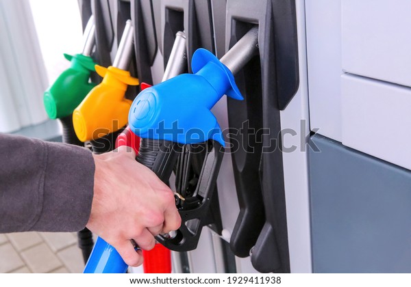 Detail of a petrol pump in a\
petrol station.Close up on fuel nozzle in oil dispenser with\
gasoline and diesel in service gas station. Blue, green, red,\
golden colors