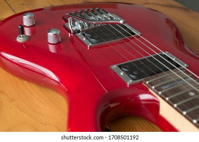 Detail photographs of a red electric guitar with rustic wood background