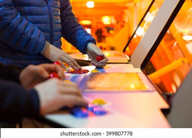 Detail Of Players Hands Interacting And Playing With Joysticks And Buttons On An Old Arcade Game In A Gaming Room