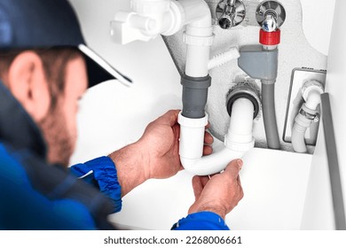 Detail of Plumber Fixing leaking Sink Pipe with Adjustable red professional wrench. - Shutterstock ID 2268006661