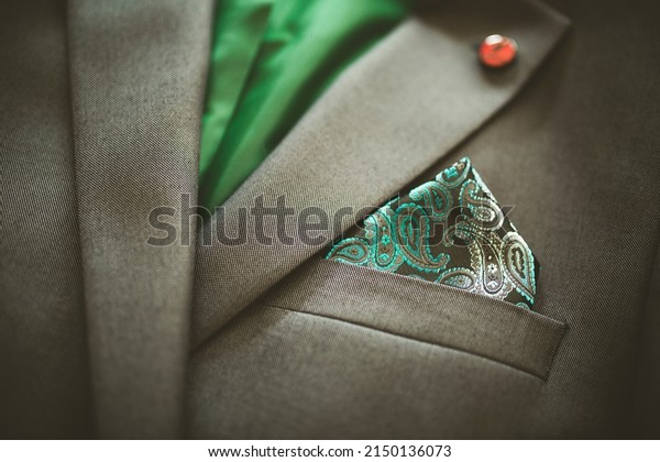 Detail of pocket\
square of man in gray\
suit.