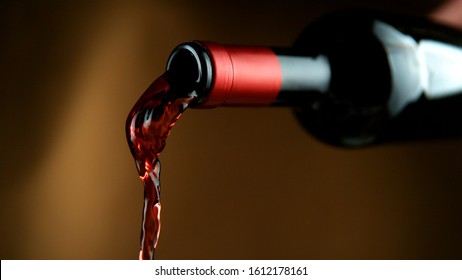 Detail of pouring red wine, dark gradient background. Free space for text
