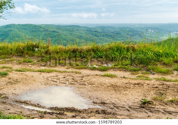 Detail of a Puddle in a trail in the mountains of\
Croatia, Istria, with signs of  tires of off road vehicles like\
jeep cars bike motorbike\
