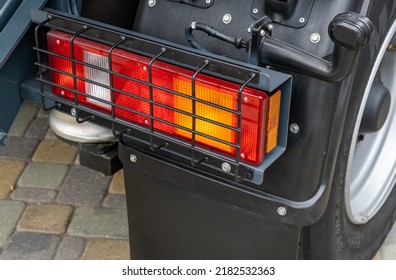 Detail Of The Rear Of A New Utility Truck. Taillights, Electrical Connectors, Plastic Mudguards, Wheels And Rims. Red Brake Lights And Orange Turn Signals. Road Safety