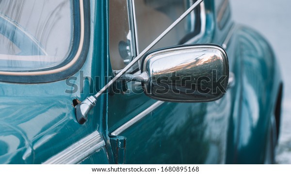 Detail of\
the rear view mirror of an old classic \
car.