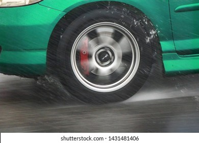 Detail Of The Rear Wheel Of A Car Driving In The Rain On A Wet Road. Aquaplaning In Road Traffic.