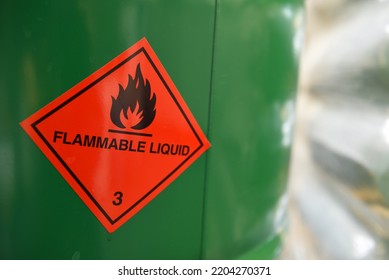 Detail of red flammable liquid pictogram on a green drum. - Shutterstock ID 2204270371
