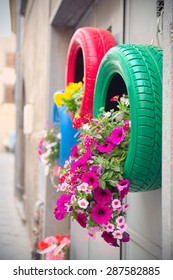 Detail of red and green tires recycled as planters with environmentally friendly method.