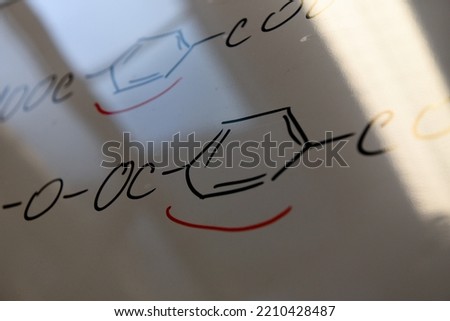 Detail of red underlined benzene nucleus in polymer chain. Chemical reaction on a white board. [[stock_photo]] © 