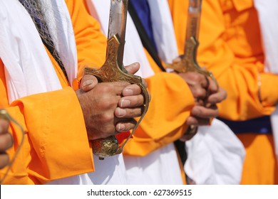 Detail of religious men Sikh during religious ceremony with sword in hand