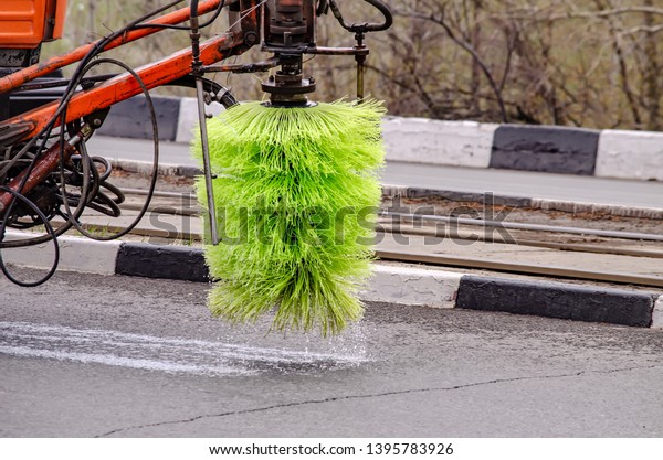 Detail of a road\
sweeper cleaning the\
streets.