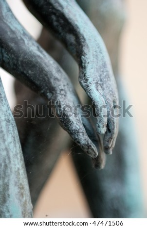 a detail of sculpted pair in love holding their hands