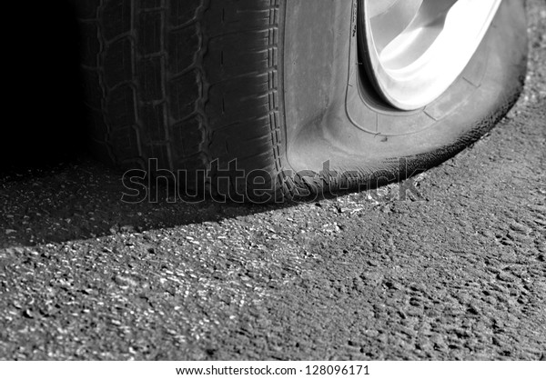 Detail Shot of a Flat Tire\
on a Car
