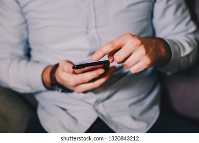 Detail Shot Of Man's Hands Using An Android Phone.