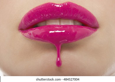 Detail Shot Of Pink Lipgloss Dripping From Woman's Lips