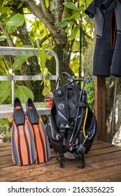 Detail Shot Of Scuba Diving Gear Ready For The Water With Set Of Fins, BCD, Octopus Regulator, Dive Tank And A Hanging Wet Suit