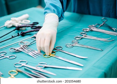 Detail shot of steralized surgery instruments with a hand grabbing a tool 