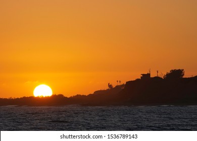 Detail Shot Of The Sunset Sunball As It Dips Behind The Beach Head Near The Lifeguard Tower In Lower Trestles In San Clemente, Southern California.