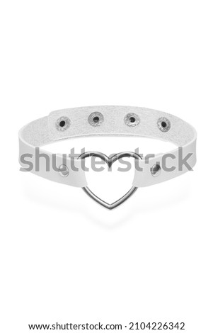 Detail shot of white leather collar with steel heart-shaped ring and metal rivets. Stylish adjustable choker with press studs is isolated on the white background.  