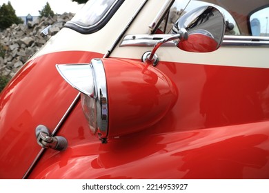 Detail Of A Small Red Vintage Car With Headlight And Sideview Mirror 