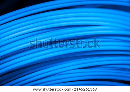 detail of a spool of blue fiber optics cable as high speed gigabit internet abstract