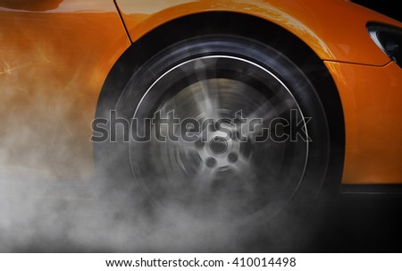 Detail of a sport car with spinning wheel, smoking, doing drifts and burnouts