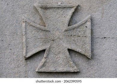 detail of stonemasonry of an iron cross on a world war one memorial.
