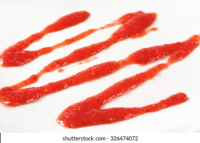 Detail Of Strawberry Puree Drizzle On White Plate