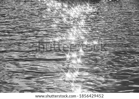 Detail of a sunlight reflecting in glittering sea. sparkling in water - background. sea water with sun glare and ripple. Powerful and peaceful nature concept. black and white