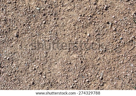 Detail of surface texture with small pebble rock on dirty ground.
