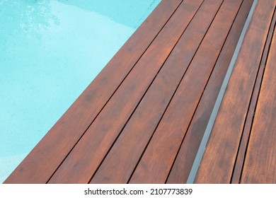 Detail of swimming pool coping and cover constructed by cumaru wood deck, hardwood decking texture next water